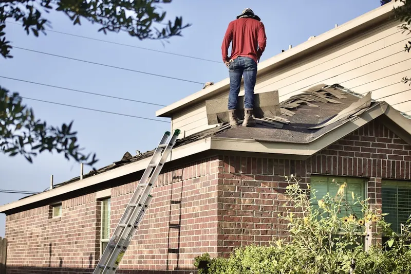 Professional roofer working on a residential roof in Burke